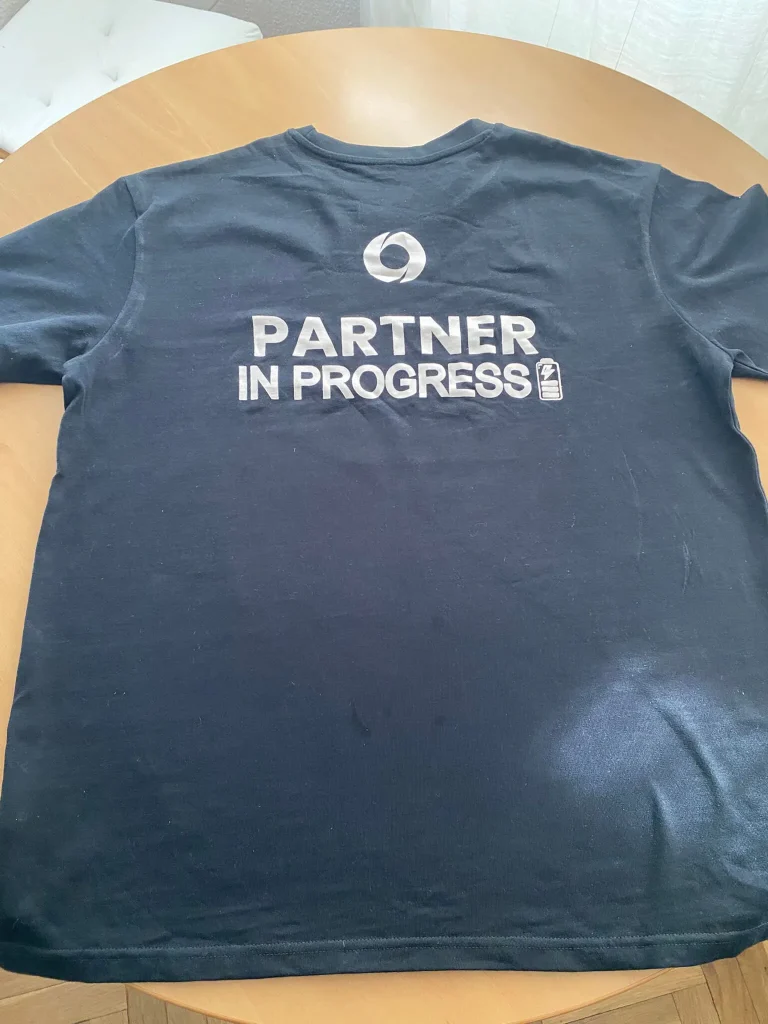 Camiseta oficial de Partner360 con la frase Partner in Progress impresa en la parte trasera